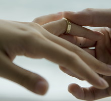 Man placing ring on woman's finger