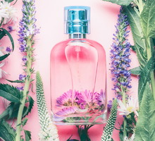 Floral Perfume bottle with plants and flowers, top view. Perfumery, cosmetics, botanical fragrance concept.