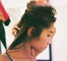Young Woman Blow Drying Hair At Home