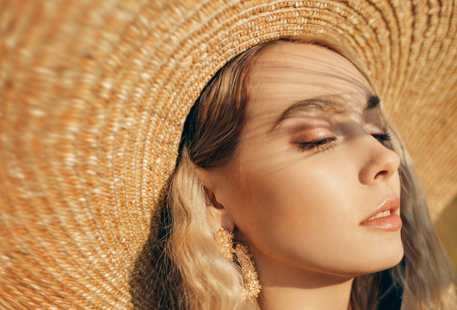 Portrait of young beautiful woman wearing straw hat