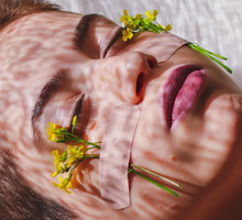High Angle View Of Woman With Flowers On Face Sleeping At Home