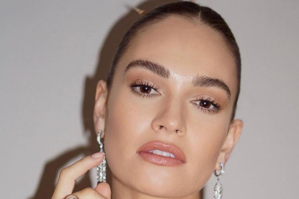 Lily James przywraca dolphin skin na listę największych przebojów makijażowych. Jak uzyskać efekt mokrego rozświetlenia?