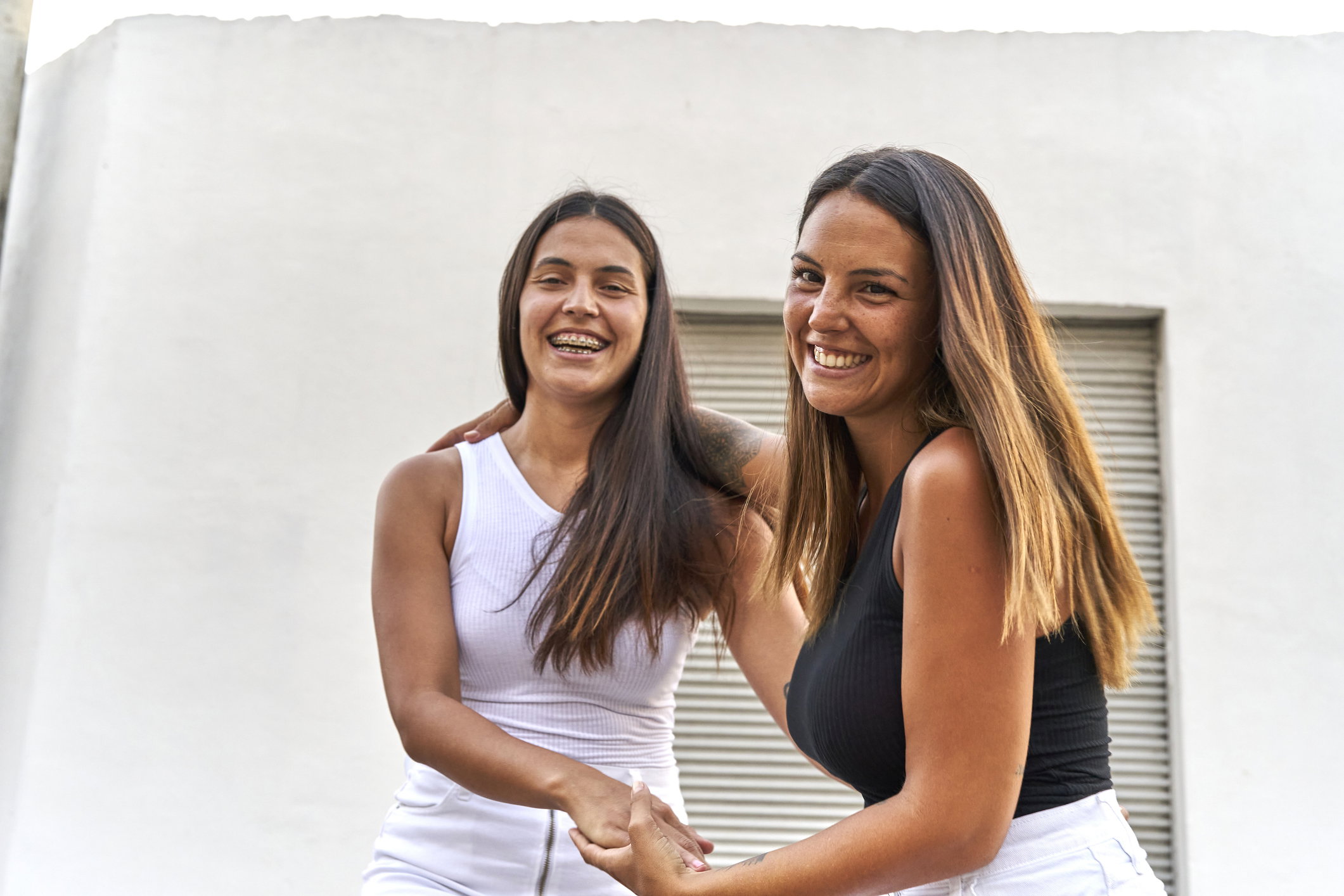 Happy young female friends laughing together while having fun on a summer day.