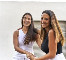 Happy young female friends laughing together while having fun on a summer day.