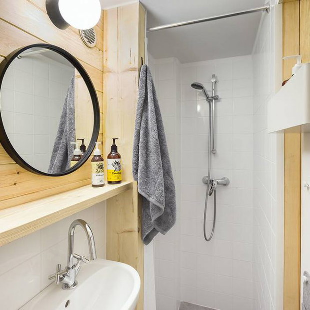 Bookworm Cabin ma 35 m2 na których mieści się łazienka, kuchnia, sypialnia na antresoli i miejsce do czytania z kominkiem.