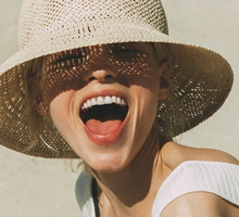 Portrait of laughing blond woman wearing summer hat