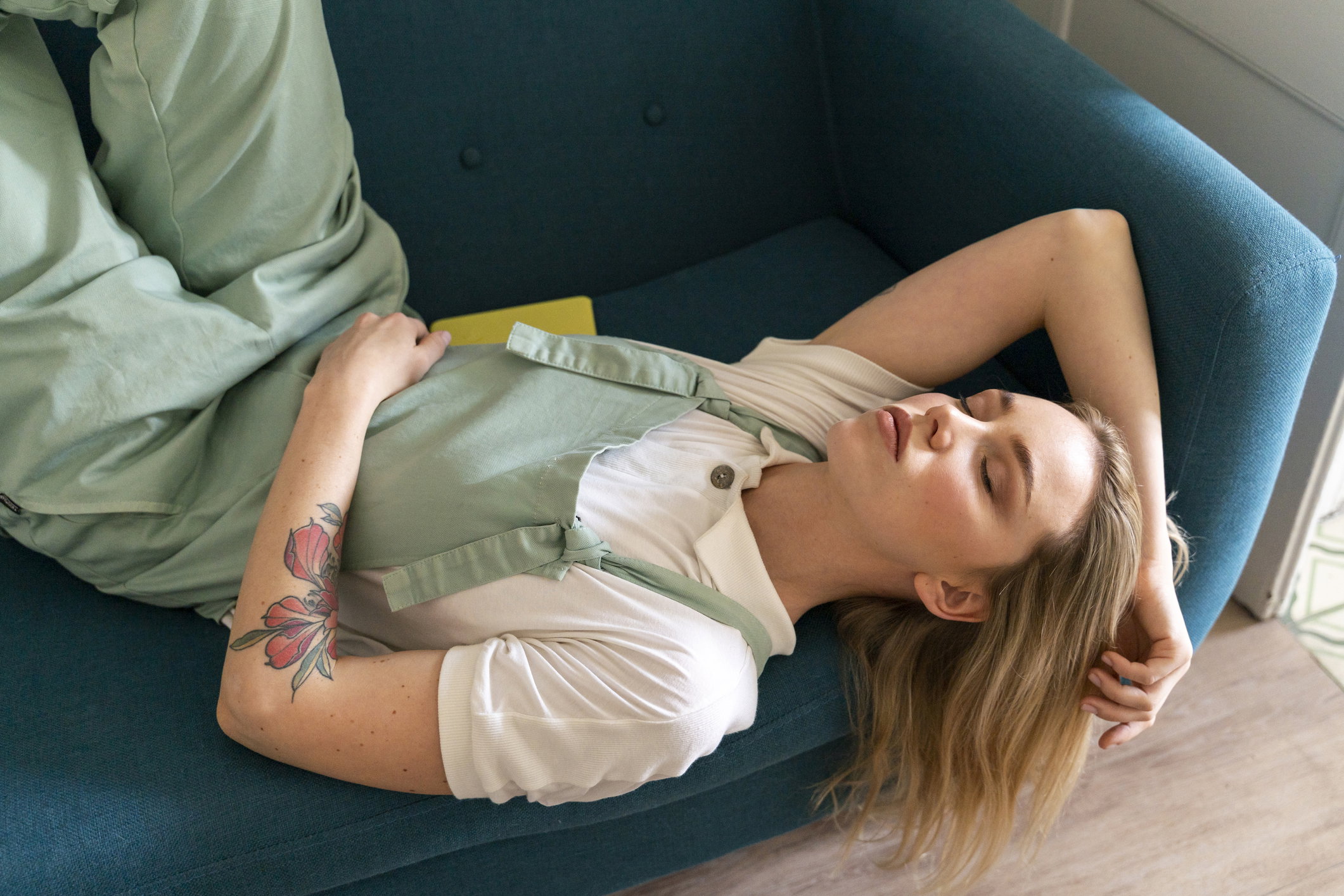 Portrait of young woman lying on couch with closed eyes