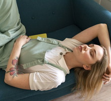 Portrait of young woman lying on couch with closed eyes