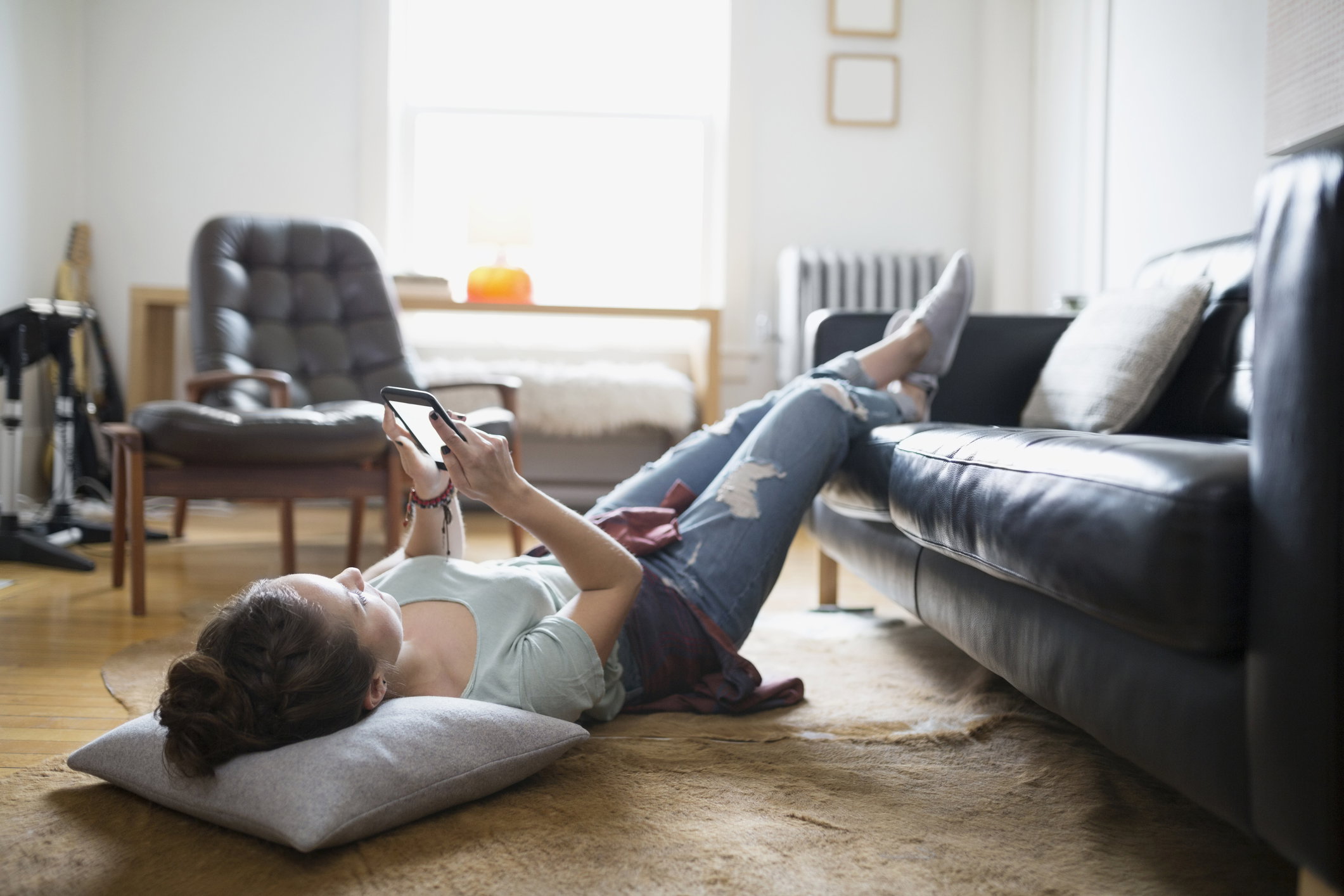 Woman laying with feet up texting cell phone