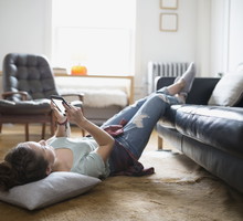 Woman laying with feet up texting cell phone