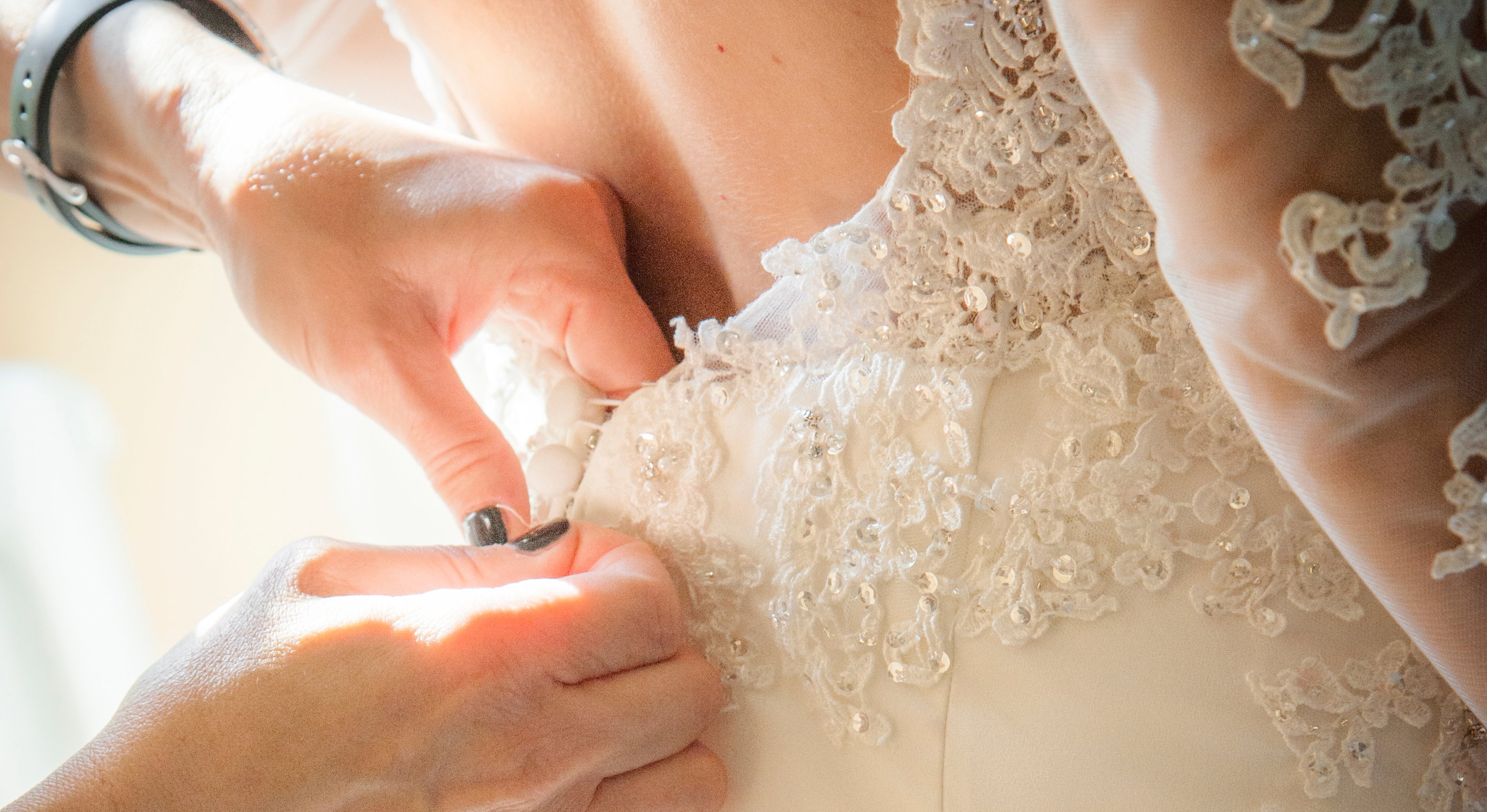 Bridesmaid Helping Bride With Dressing In Domestic Room