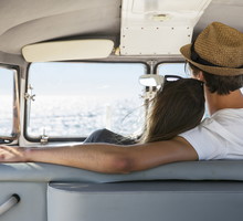Group of friends with a surf van by the sea