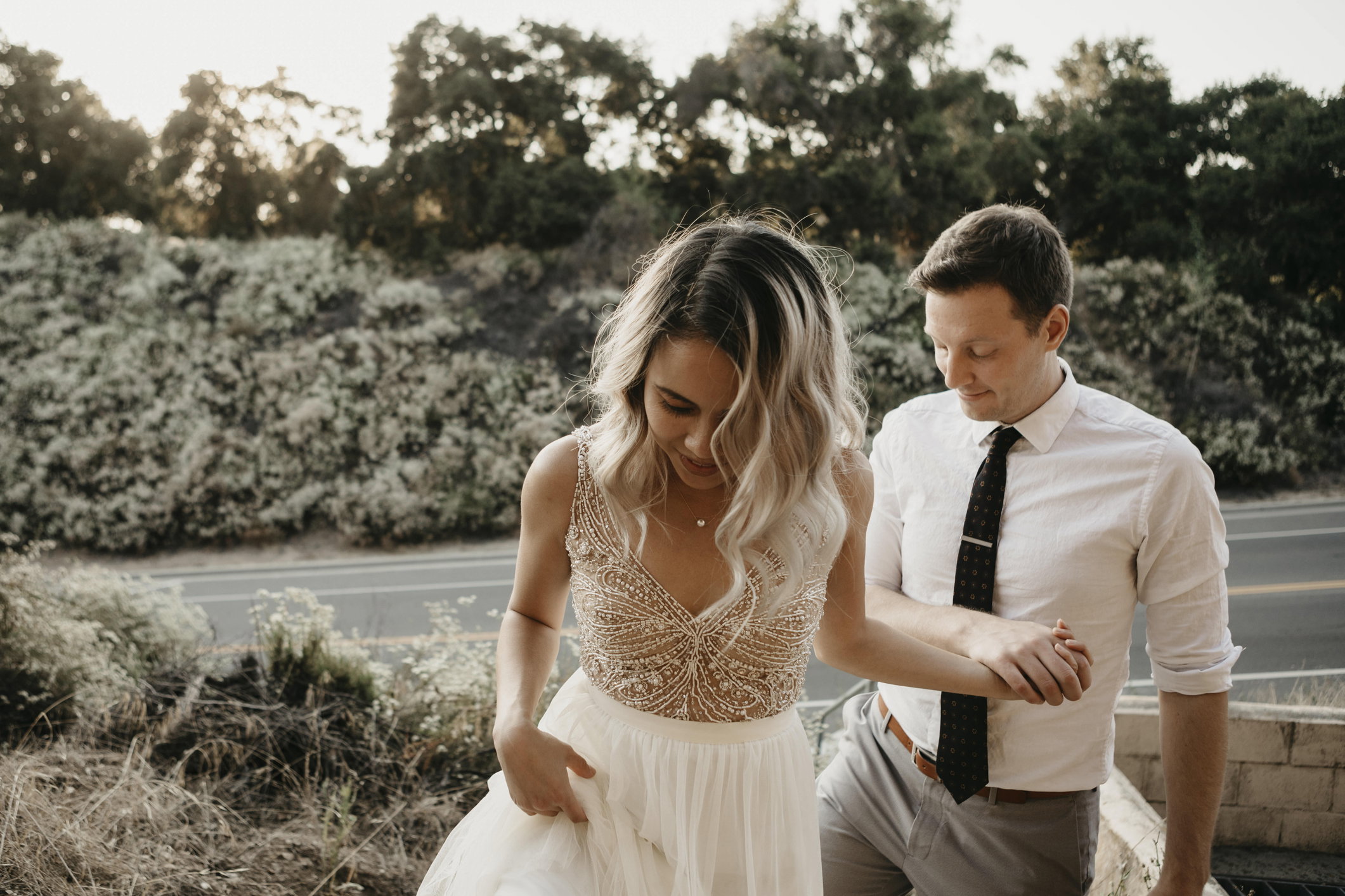 Affectionate bride and groom holding hands outdoors