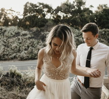 Affectionate bride and groom holding hands outdoors