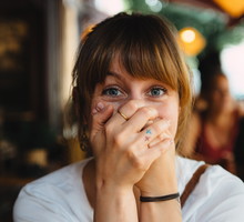 Close-Up Portrait Of Surprised Woman With Hands Covering Mouth
