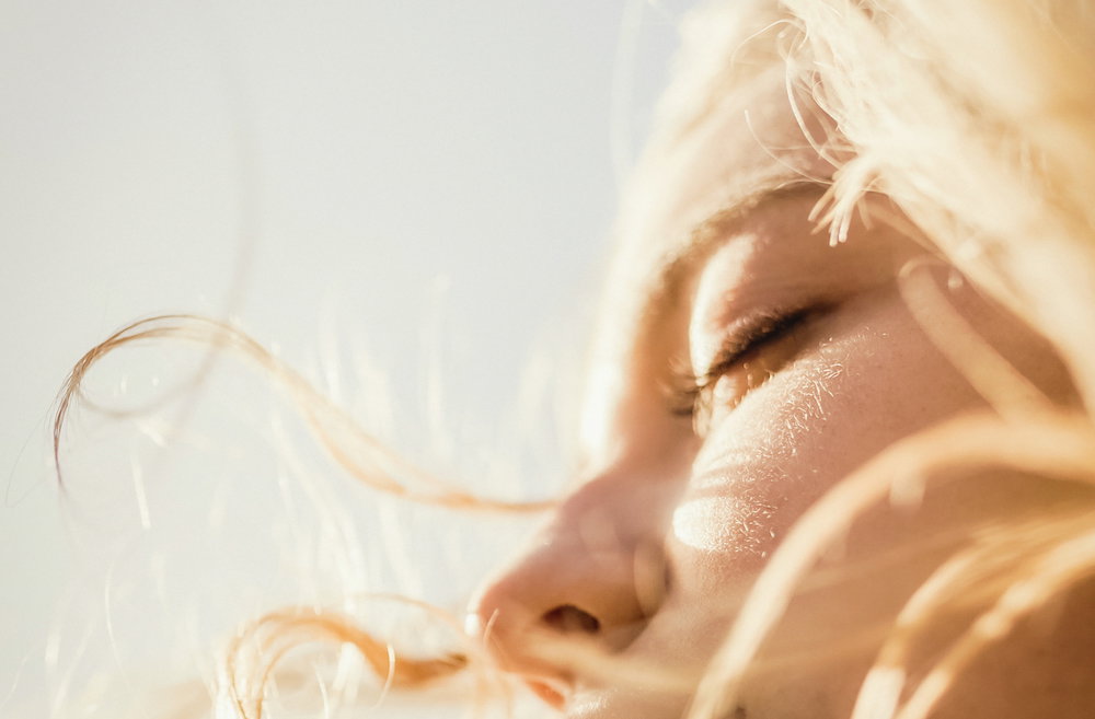 Close up serene woman enjoying wind and sunshine