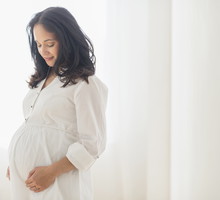 Pregnant Hispanic woman touching her belly