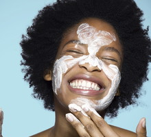 Young female applying face cream / mask