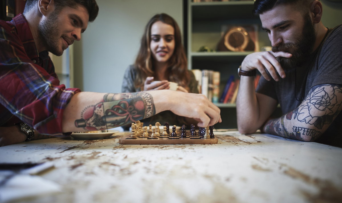 Young tattooed males playing chess