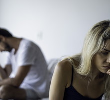 Upset couple sitting in bedroom