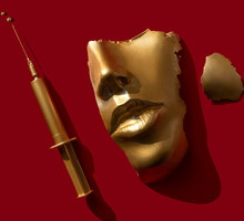 Gold colored syringe and face/ mask on the red background.