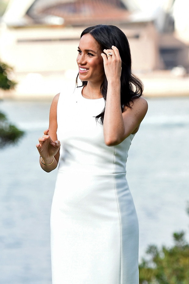 Pod jasną sukienką delikatnie odznaczał się ciążowy brzuszek Meghan.