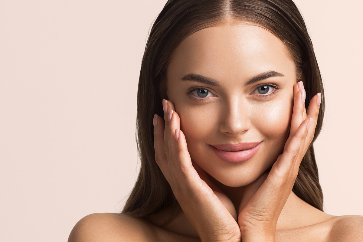 Beautiful woman face close up natural make up hand touching face