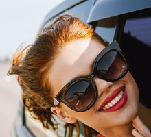 woman looking out of car window wearing sunglasses travel lifestyle