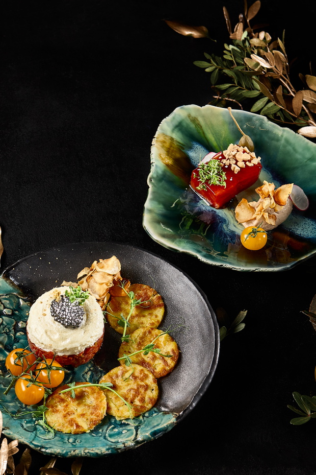 Elegant Snack Set: Beef Tartare, Pate, and Draniki on Artistic Plates Against a Black Background