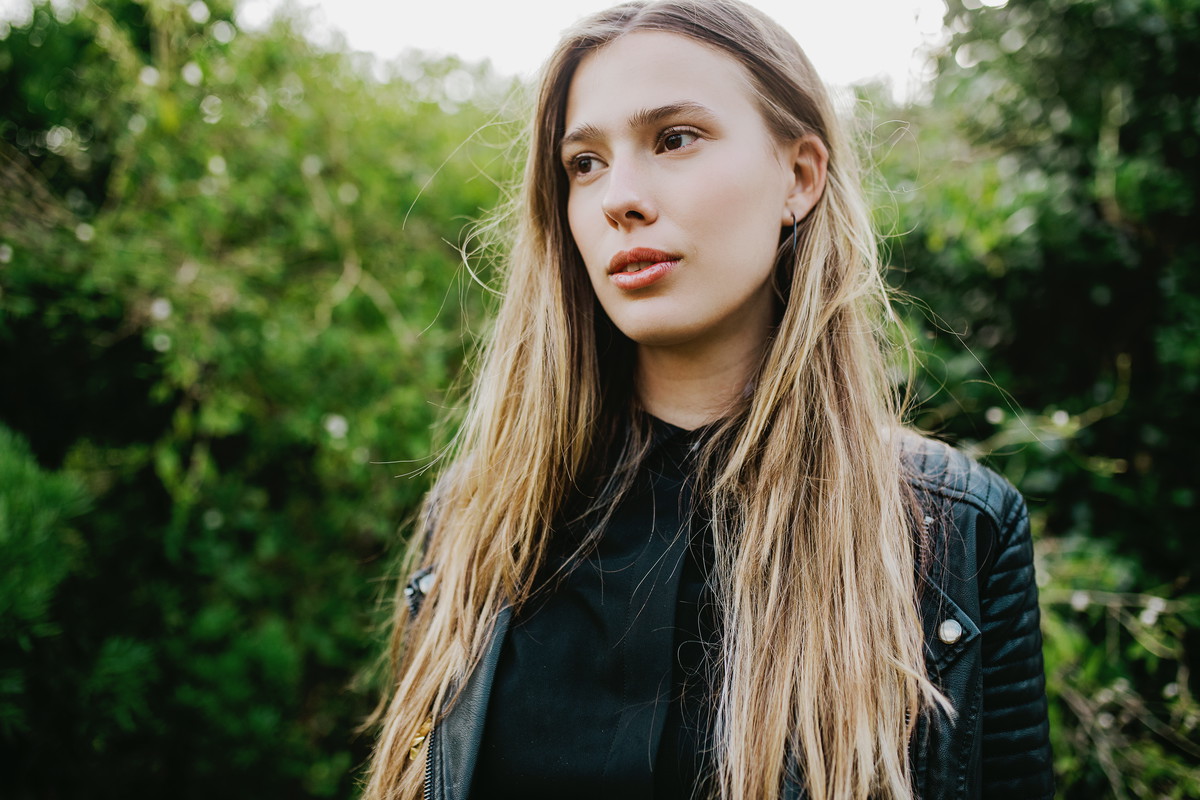 Beautiful using woman looking to side with green foliage background