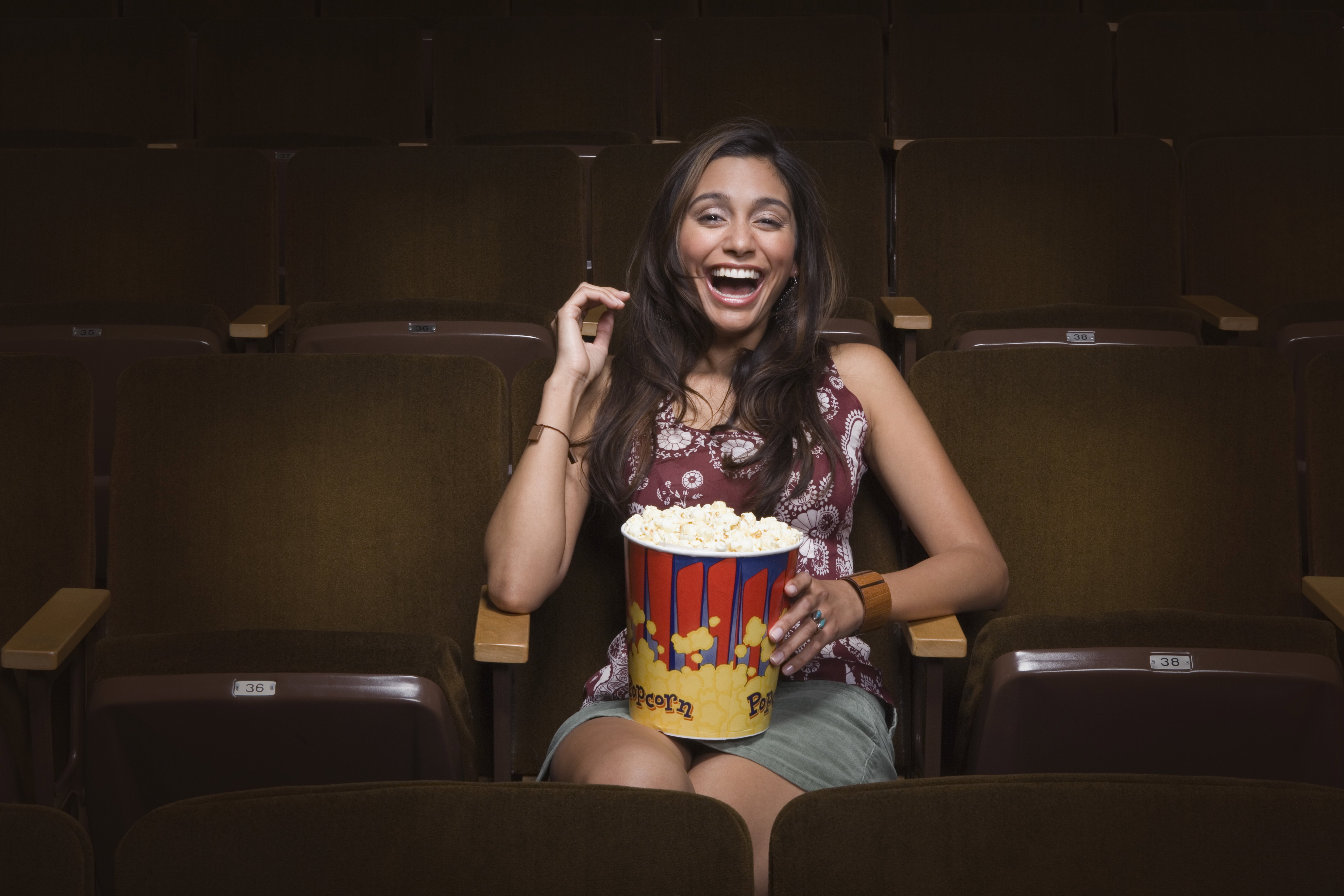 Woman laughing in movie theatre