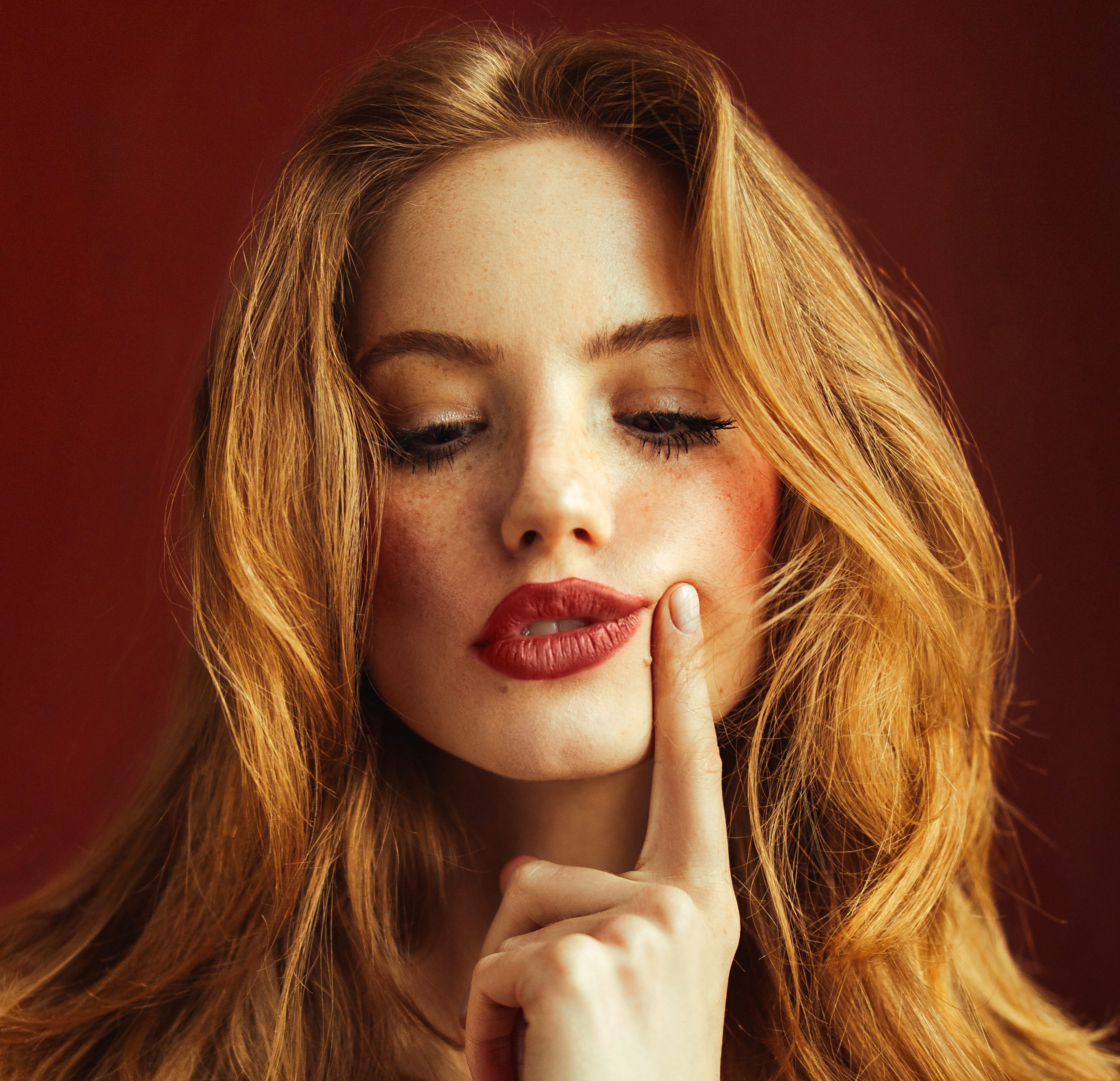 Young suspicious woman with long red hair