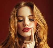 Young suspicious woman with long red hair