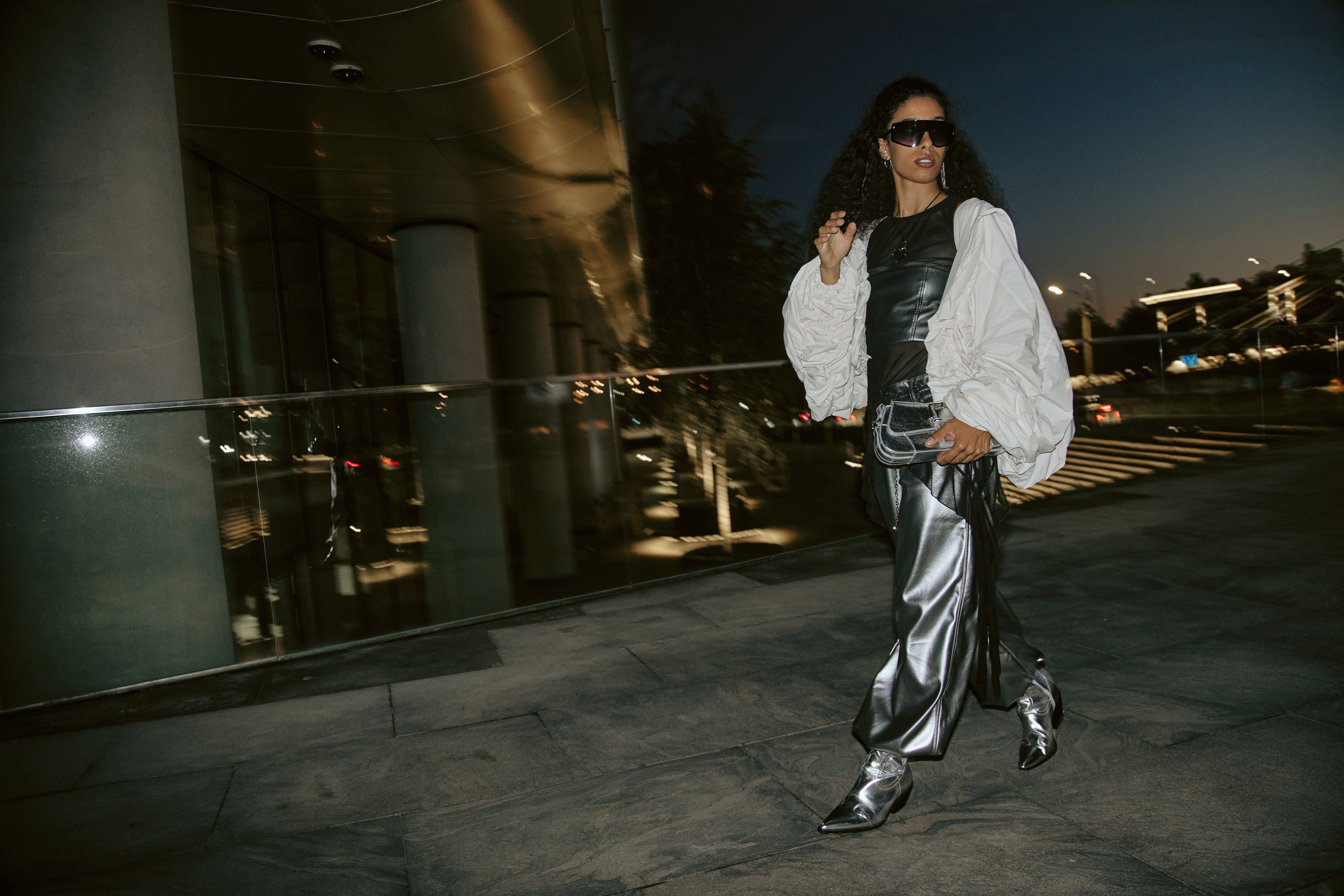 Female Model in Silver Pants Walking in Night City Street