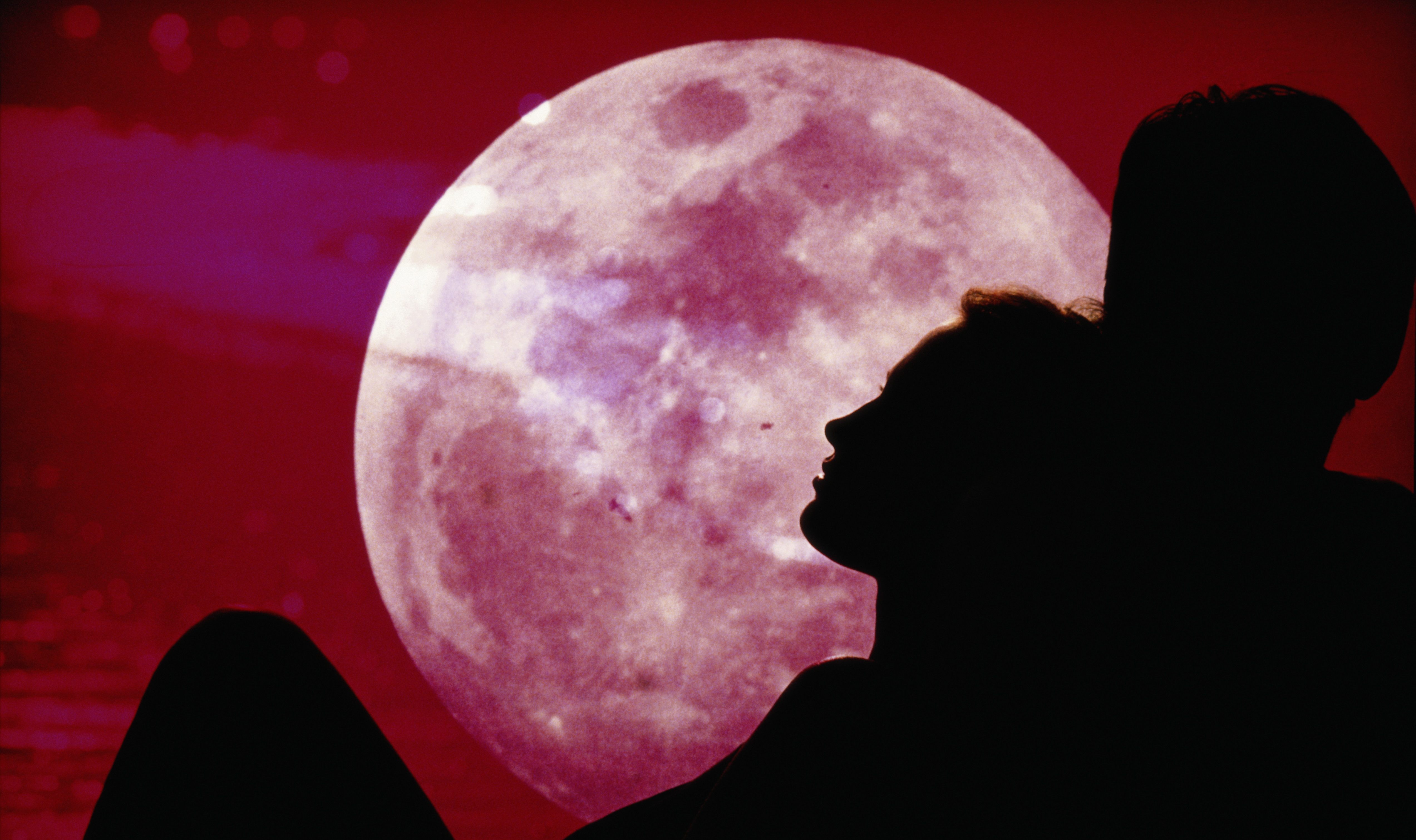 Silhouette of couple, moon in background