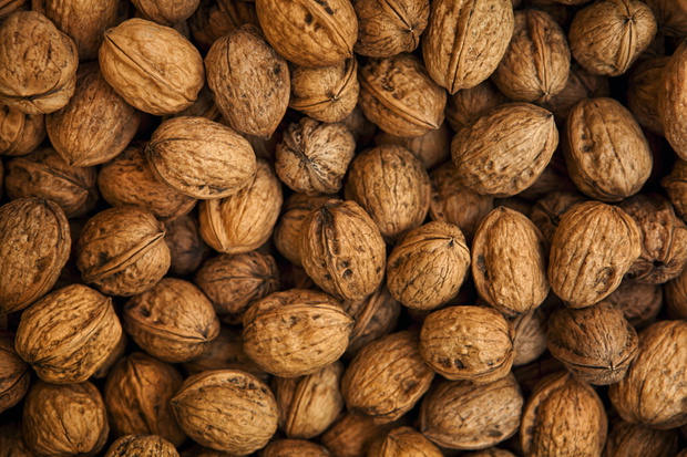 Walnuts in their shells arranged on a wooden surface