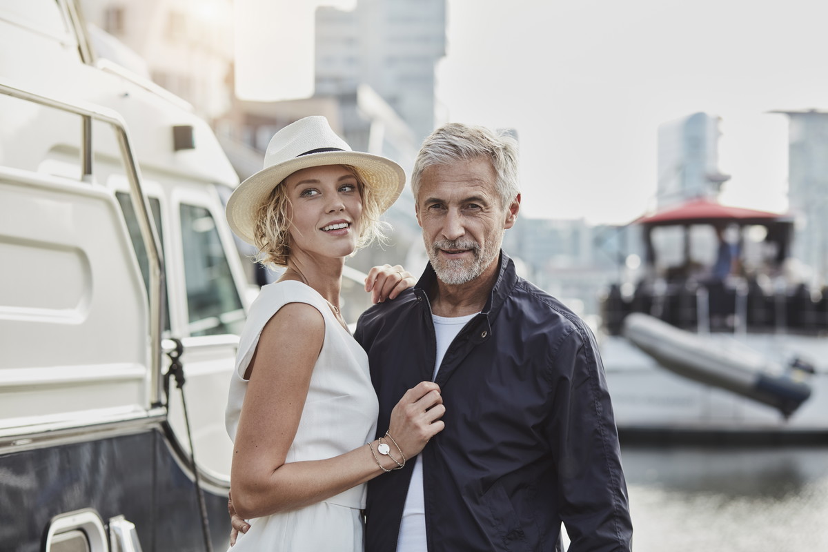 Older man and young woman at a marina next to a yacht