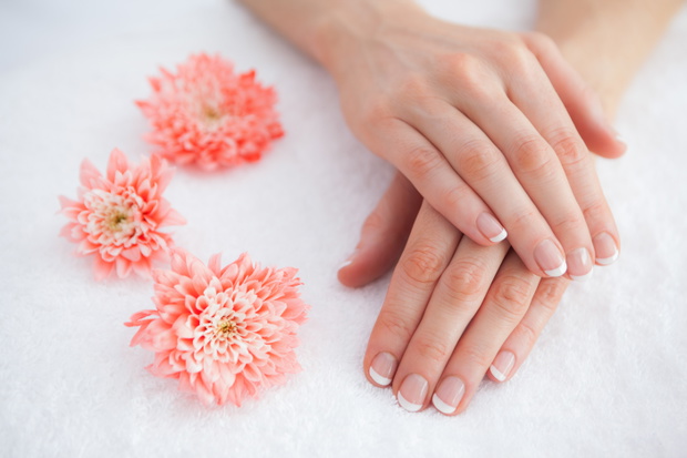 Flowers with french manicured fingers at spa center