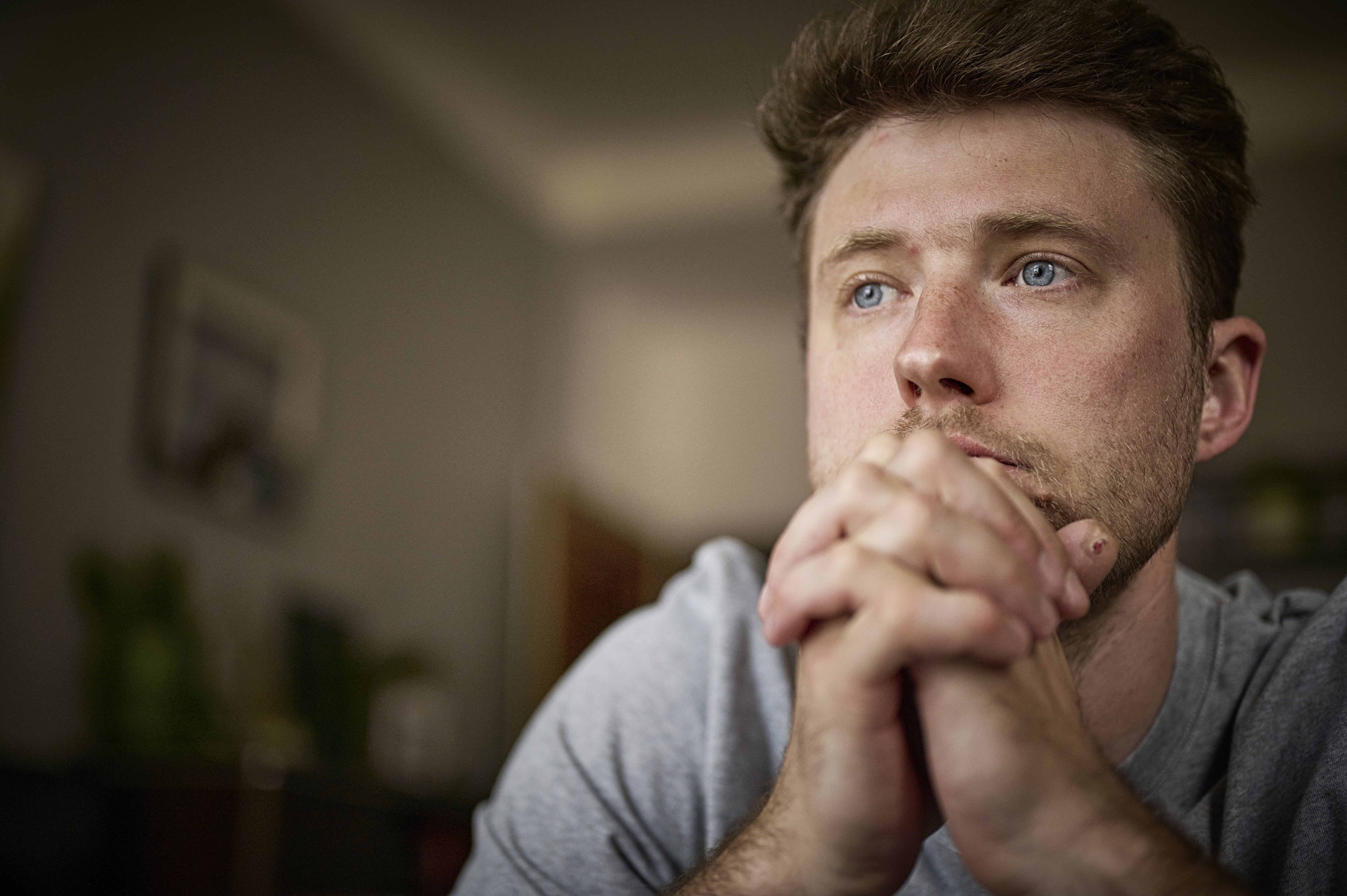 Sad man praying at home