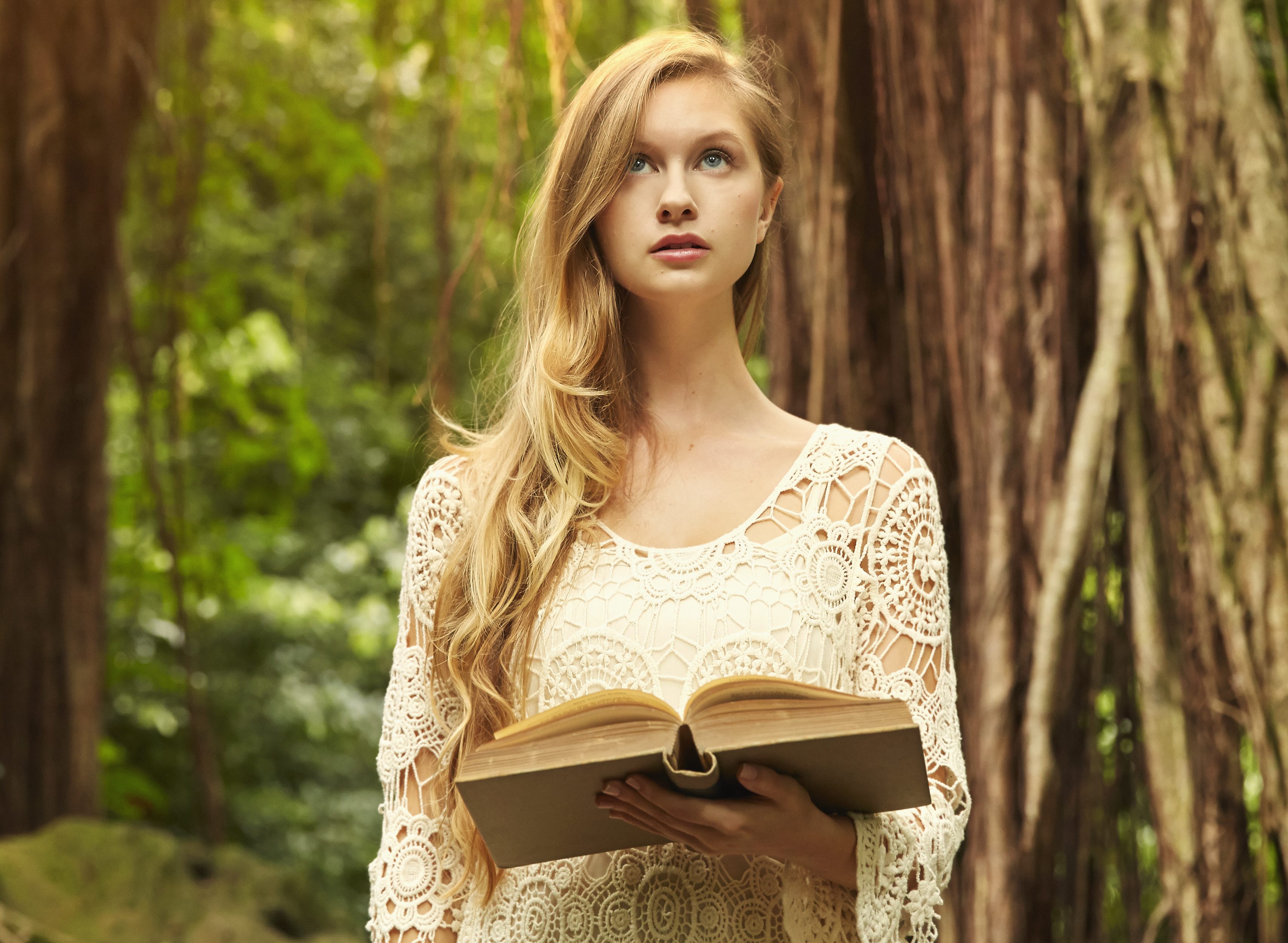 Caucasian woman reading book under banyan trees
