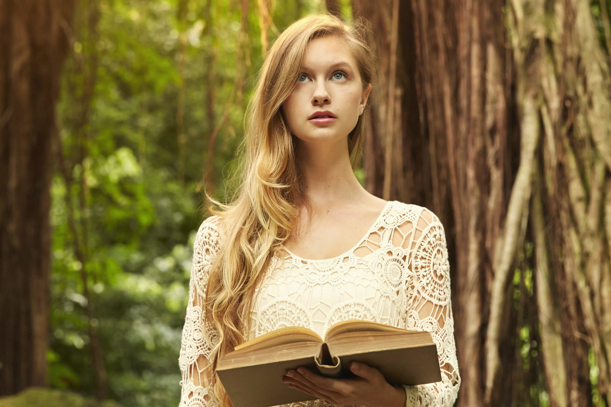 Caucasian woman reading book under banyan trees