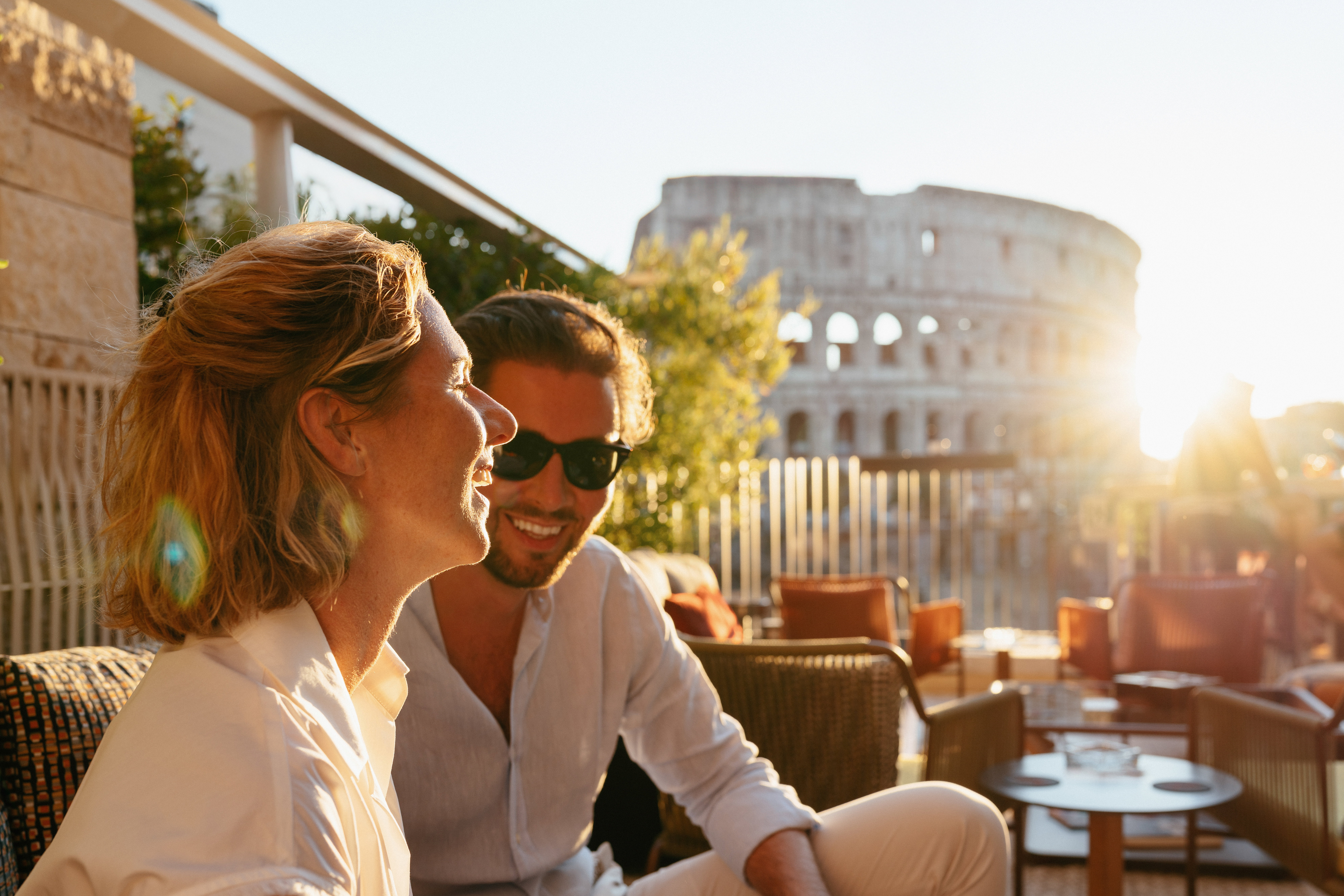 Couple enjoys sunset views of the Colosseum.  Romance, travel.