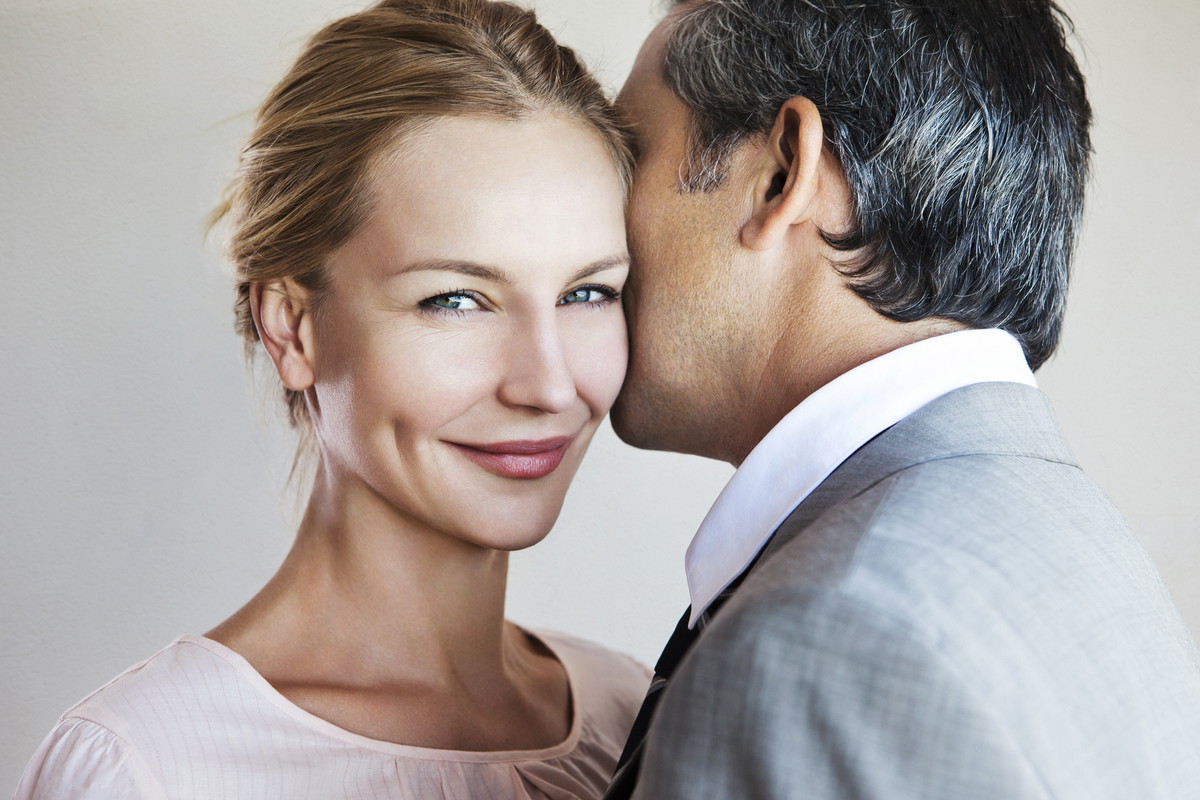 Man whispering to smiling woman