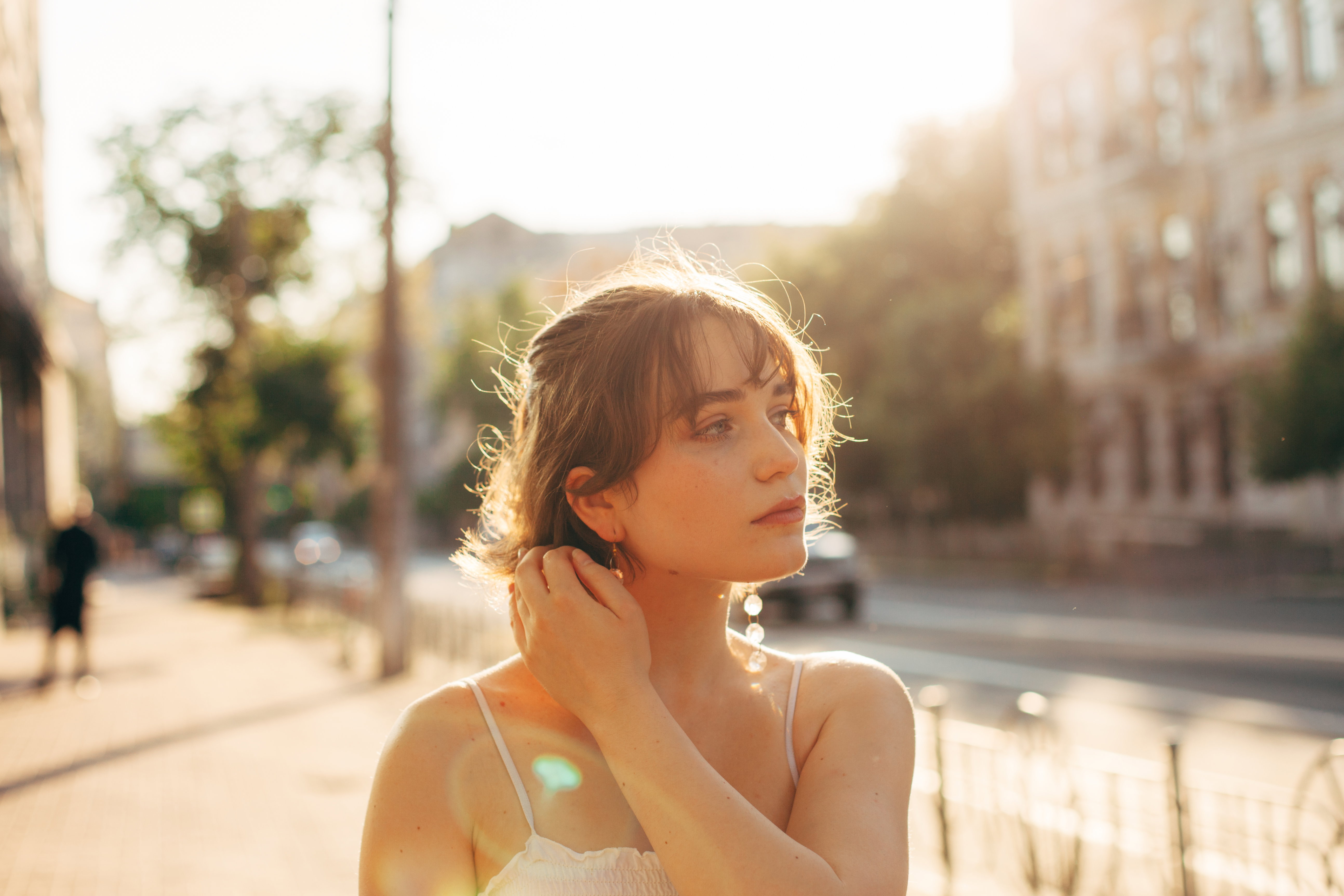 Beautiful young woman walking on the city street during summer