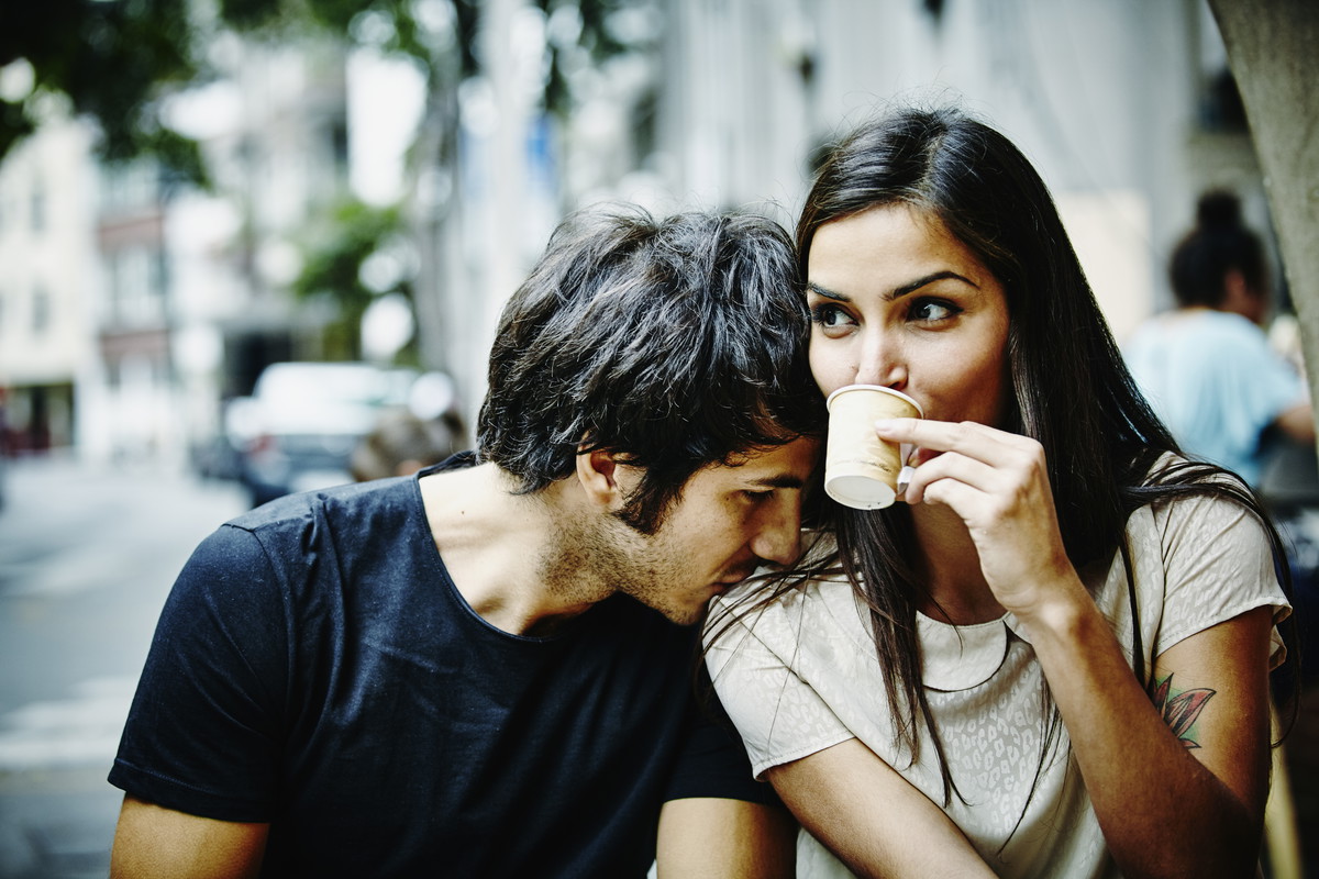 Couple sitting at city cafe drinking espresso