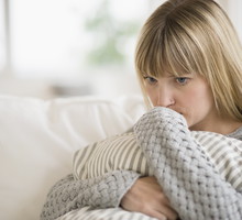 Woman sitting on sofa and thinking