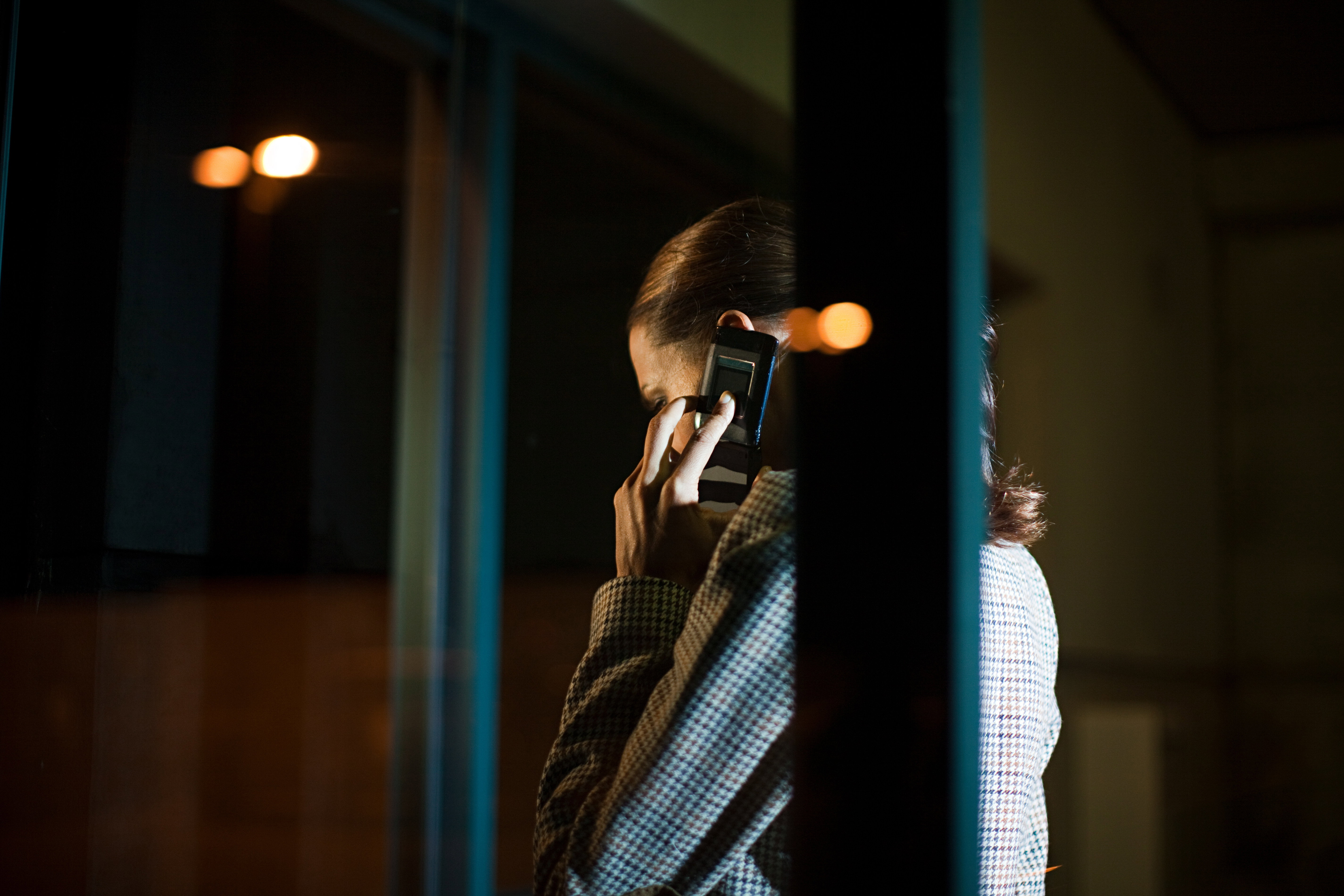 Businesswoman using mobile phone in office at night