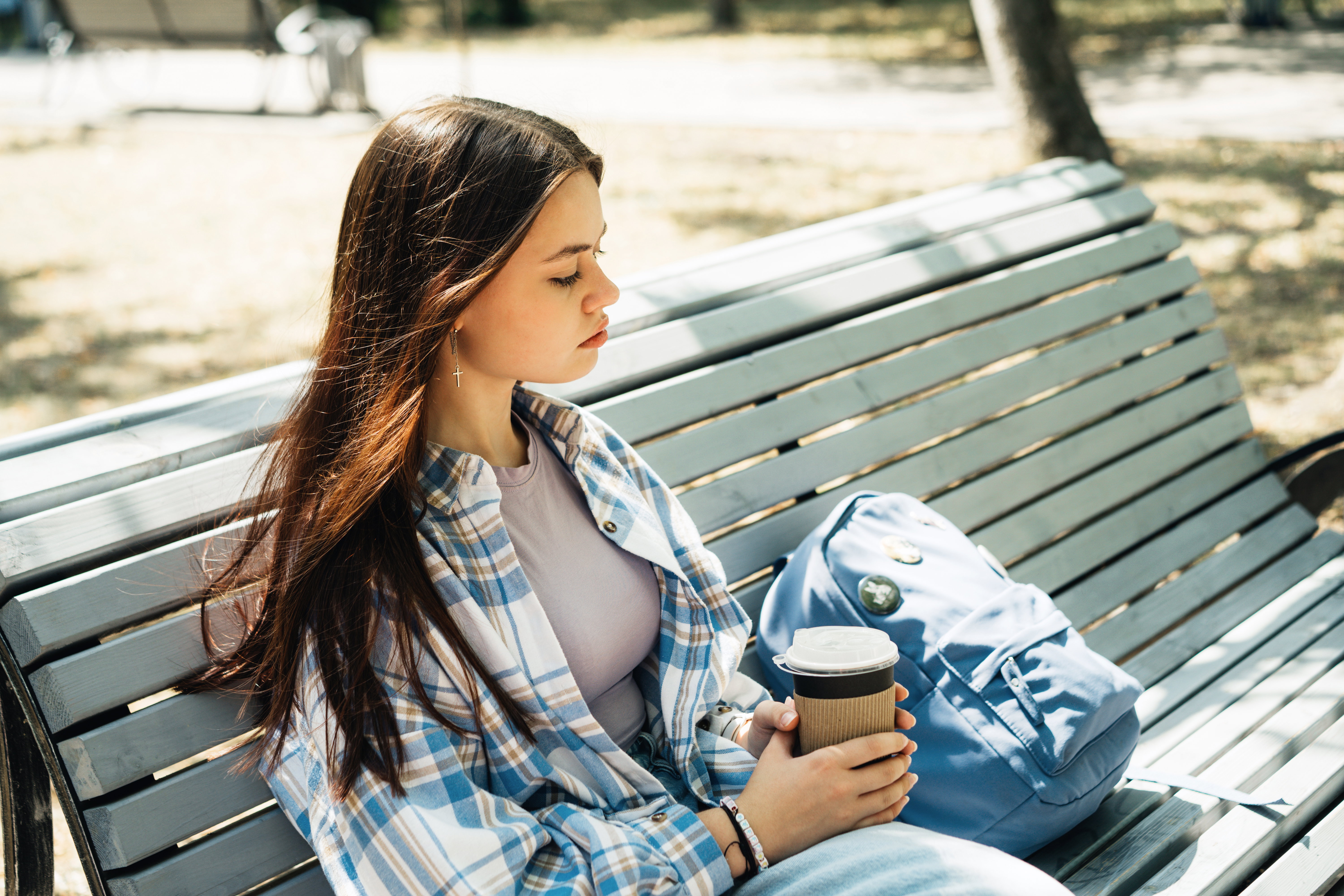 Portrait of teenage girl sitting on the bench in the park