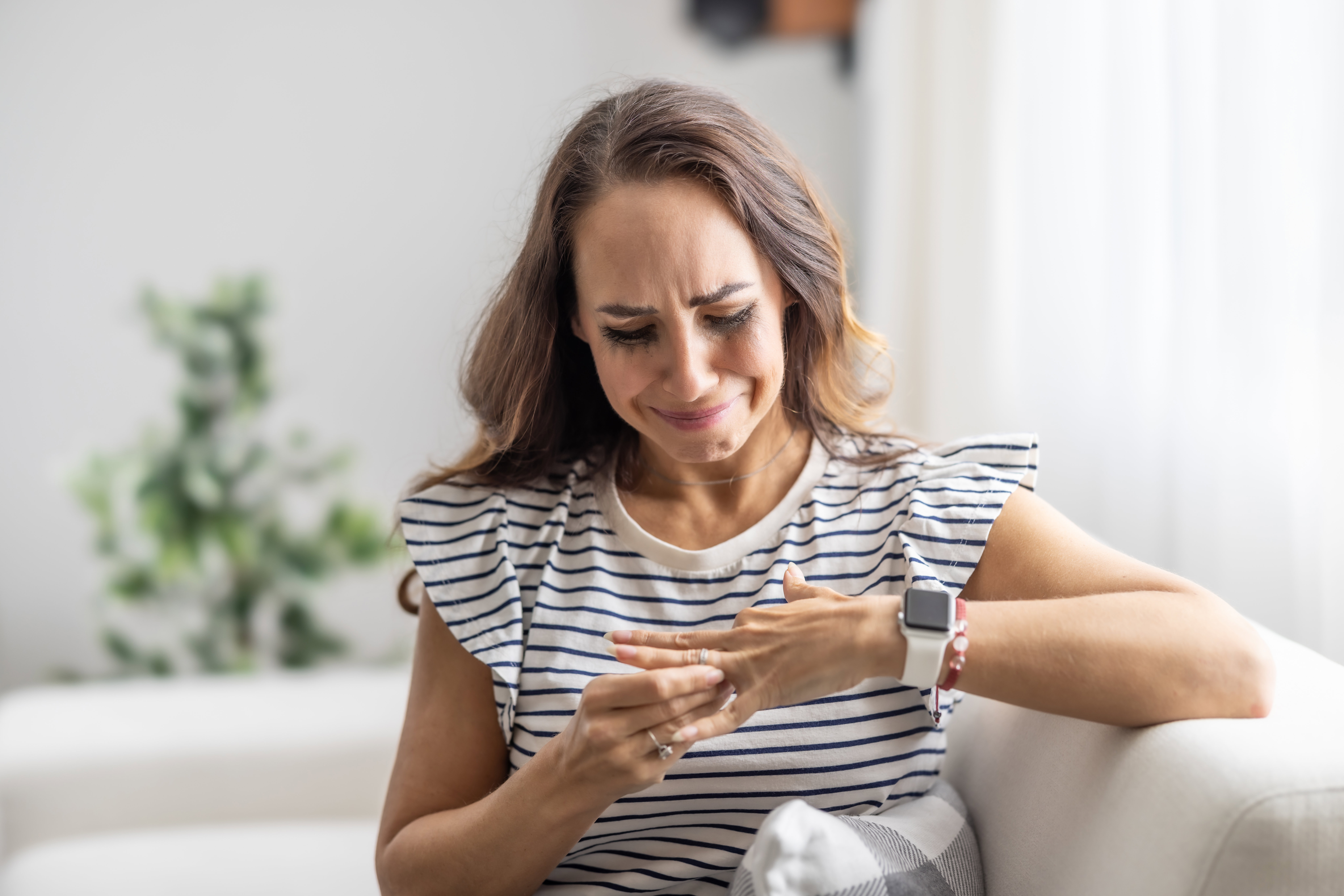 Unhappy and tearful woman taking off her wedding ring after divorcing her husband