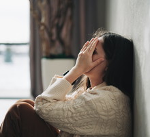 Silhouette of sad and depressed woman sitting on the floor at home
